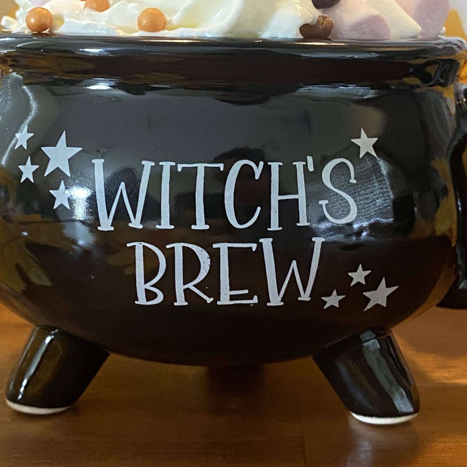 Close-up of Witch's Brew text and glossy black glaze on ceramic mug
