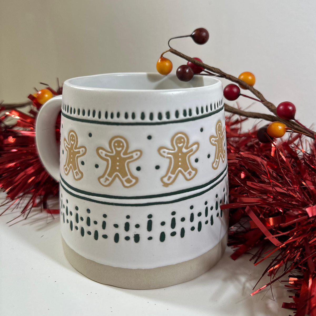Close view of the Gingerbread Man Mug showing the gingerbread men, green stripes and dotted pattern on white stoneware