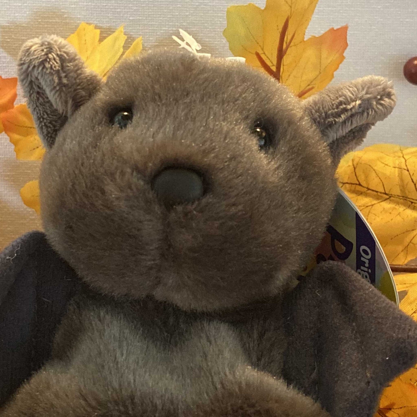 Close-up of Palm Pals Luna the Halloween Bat plush toy's face and wings