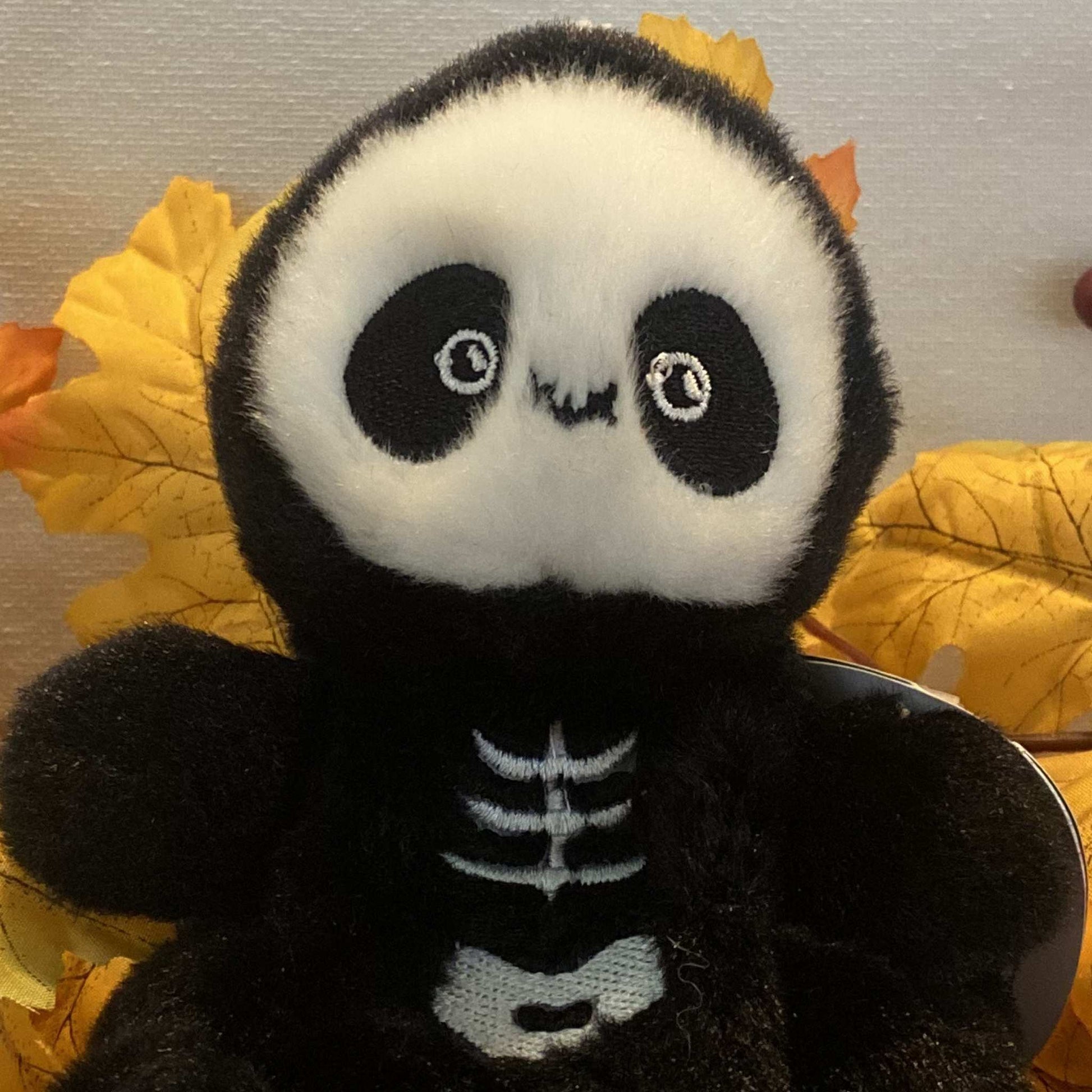 Close-up of Palm Pals Skelly the Skeleton plush toy's embroidered face