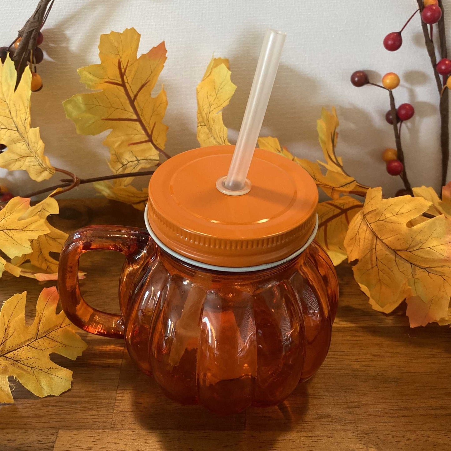 Pumpkin glass tumbler with orange screw lid and clear straw fitted