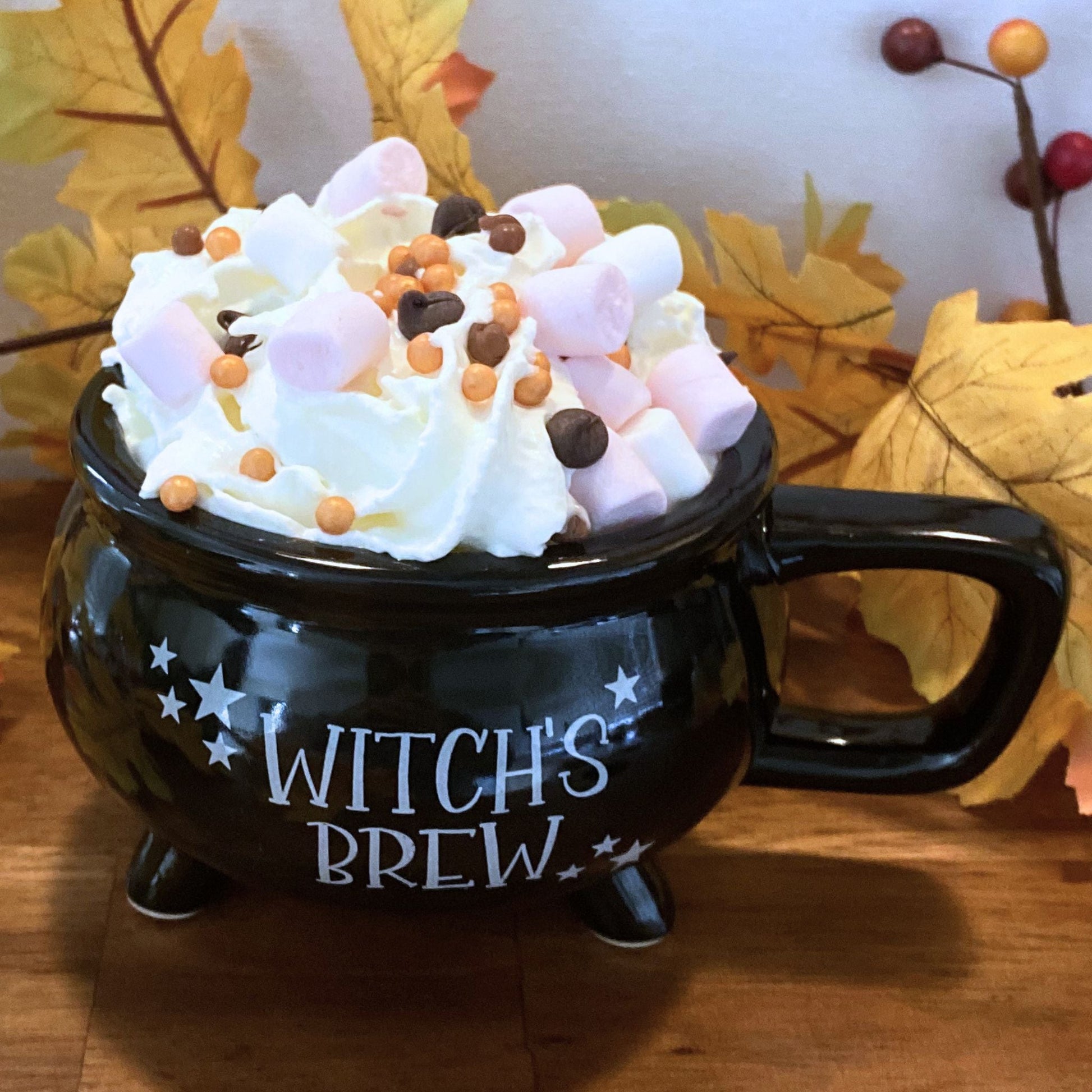 Close-up of whipped cream, marshmallows, and chocolate topping on witch's brew mug